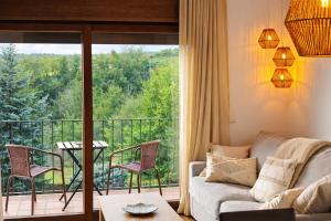 a living room with a couch and a balcony at Allotjaments Vall de Muntanyes in Molló