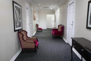 a hallway with three red chairs and a table at Marilyn Boutique Hotel in Durban
