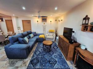 a living room with a blue couch and a tv at Casa de los Suenos Granada in El Turro