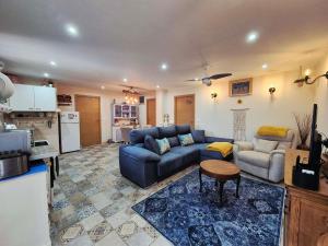 a living room with two couches and a kitchen at Casa de los Suenos Granada in El Turro