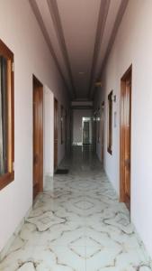 an empty hallway with a tile floor and wooden doors at Velora Inn in Jakarta +2 photos