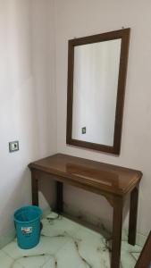 a wooden table with a mirror on a wall at Velora Inn in Jakarta