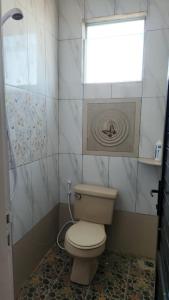 a small bathroom with a toilet and a window at Velora Inn in Jakarta