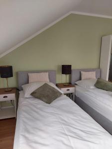 zwei Betten in einem Zimmer mit zwei Lampen auf Tischen in der Unterkunft Apartment Senfnest in Ober-Ramstadt