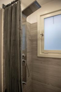 a shower with a shower curtain in a bathroom at Infinite Blue Suites in Agia Marina Aegina +43 photos
