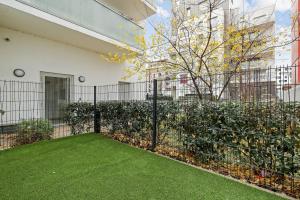 a garden with a fence and green grass at NK Apartment in Bobigny in Bobigny