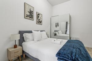 a bedroom with a large white bed and a mirror at NK Apartment in Bobigny in Bobigny