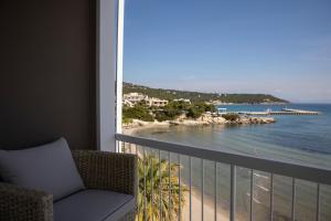a room with a balcony with a view of the ocean at Infinite Blue Suites in Agia Marina Aegina