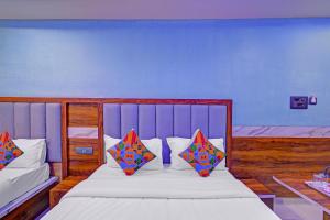 a bedroom with a bed with two pillows on it at FabHotel SV Grand in Hyderabad