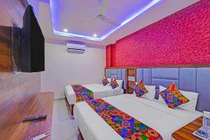 a hotel room with two beds and a tv at FabHotel SV Grand in Hyderabad