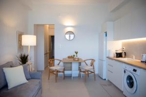 a kitchen and living room with a table and a couch at Infinite Blue Suites in Agia Marina Aegina