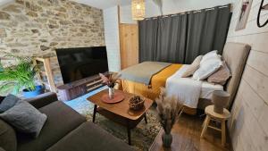 a living room with a bed and a couch at Le Moulin de Trévelo in Caden