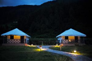 two tents in a field at night with lights at Haa Valley Camp in Kechungka +3 photos