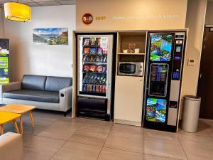 a gas station with a soda machine and a couch at B&B HOTEL Valence TGV Romans in Alixan