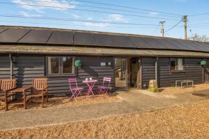 a house with pink chairs and a table in front of it at 2 Bed in Hastingleigh oc-c36343 in Hastingleigh