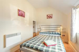 a bedroom with a bed with a checkered blanket at 2 Bed in Hastingleigh oc-c36343 in Hastingleigh