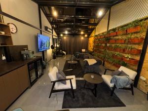 a room with couches chairs and tables and a tv at 5 Crowns - Osijek - Free EV - Self check in - Pool in Osijek