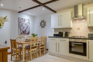 a kitchen with white cabinets and a table and chairs at 3 Bed in Shanklin oc-b36038 in Shanklin