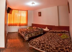 Habitación de hotel con 2 camas y ventana en Hotel Olímpica, en Arequipa