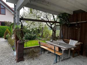 a picnic table and a bench under a pergola at Black & White in Ilmmünster