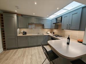a kitchen with blue cabinets and a table with a bottle of wine at 1 Bed in Hexham oc-g37537 in Hexham +8 photos