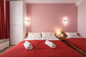 a bedroom with two beds with towels on a red blanket at Vila Kosta City Center Port in Ohrid
