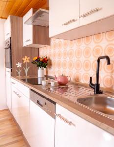 a kitchen with white cabinets and a sink at Elfriedes' Ferienhäuschen in Marktschorgast