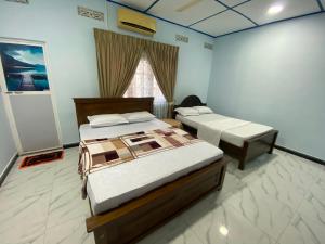 a bedroom with two beds and a window at Shans Villa in Trincomalee