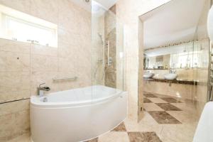 a bathroom with a tub and a toilet and two sinks at The Ayrlington Guesthouse in Bath +140 photos
