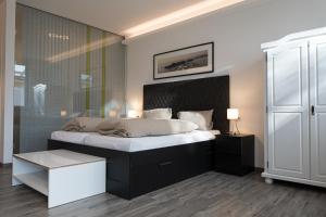 a bedroom with a large bed with a black headboard at Black & White in Ilmmünster