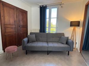 a living room with a couch and a window at "Le Cocon Douessin" en hyper centre ! in Doué-la-Fontaine