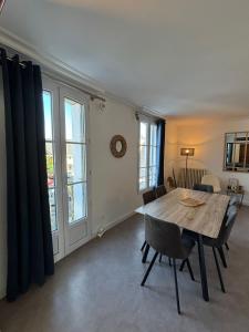 a dining room with a wooden table and chairs at "Le Cocon Douessin" en hyper centre ! in Doué-la-Fontaine +9 photos