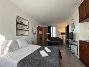 a bedroom with a large bed and a living room at "Le Cocon Douessin" en hyper centre ! in Doué-la-Fontaine