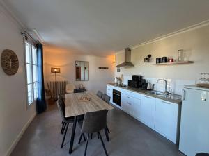 a kitchen with a wooden table and a dining room at "Le Cocon Douessin" en hyper centre ! in Doué-la-Fontaine
