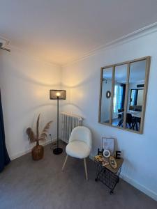 a living room with a chair and a mirror at "Le Cocon Douessin" en hyper centre ! in Doué-la-Fontaine