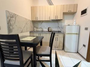 a kitchen with a table and chairs and a refrigerator at Vila 125 Apartments & Restaurant in Tirana