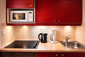 a kitchen with a sink and a microwave at Duplex pour 2-4 personnes à Monflanquin - Piscine - Terrasse - Parking - Campagne - Lot-et-Garonne - draps inclus in Monflanquin +11 photos