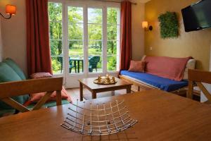 a living room with a table and a window at Duplex pour 2-4 personnes à Monflanquin - Piscine - Terrasse - Parking - Campagne - Lot-et-Garonne - draps inclus in Monflanquin
