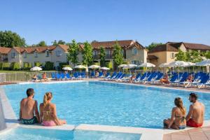 a group of people sitting around a swimming pool at Duplex pour 2-4 personnes à Monflanquin - Piscine - Terrasse - Parking - Campagne - Lot-et-Garonne - draps inclus in Monflanquin