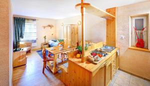 uma cozinha com armários de madeira e uma mesa num quarto em Apartmány Renomal em Tatranská Lomnica