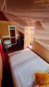 a bedroom with a bed with a canopy at Maison d'hôtes tilleli in Tamnougalt