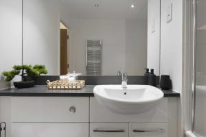 a white bathroom with a sink and a mirror at Alaska apartmans in London