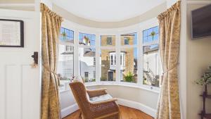 a room with a chair and a large window at Room with a View at Anchor Down Cottage in Ryde +8 photos