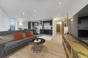 a living room with a gray couch and a table at Alaska apartmans in London