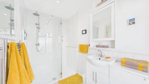 a white bathroom with a sink and a shower at Room with a View at Anchor Down Cottage in Ryde