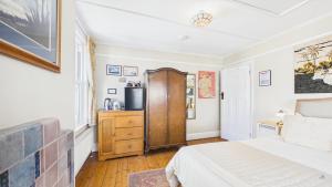 a bedroom with a bed and a dresser and a window at Room with a View at Anchor Down Cottage in Ryde