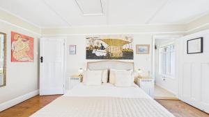 a white bedroom with a large bed with white pillows at Room with a View at Anchor Down Cottage in Ryde