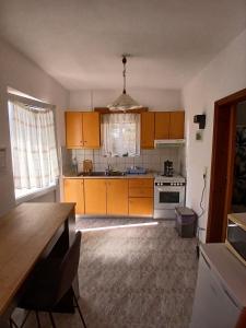 a kitchen with orange cabinets and a sink and a stove at Seva' s Studios in Livadia