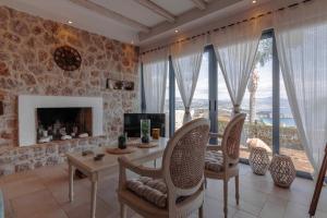 a living room with a table and chairs and a fireplace at Lilian Horizon in Tolo