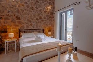 a bedroom with a bed with two candles on a table at Lilian Horizon in Tolo +22 photos